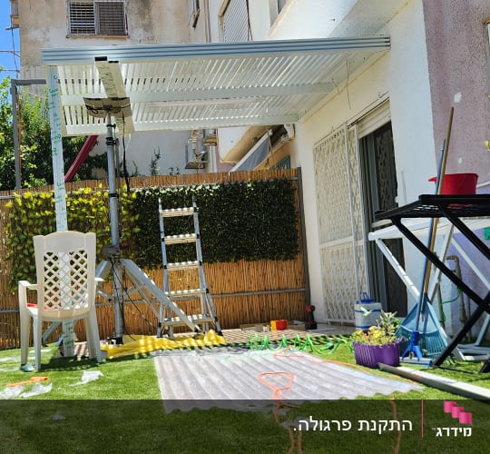 פרגולה מאלומיניום מותקנת בחצר עם דשא סינתטי